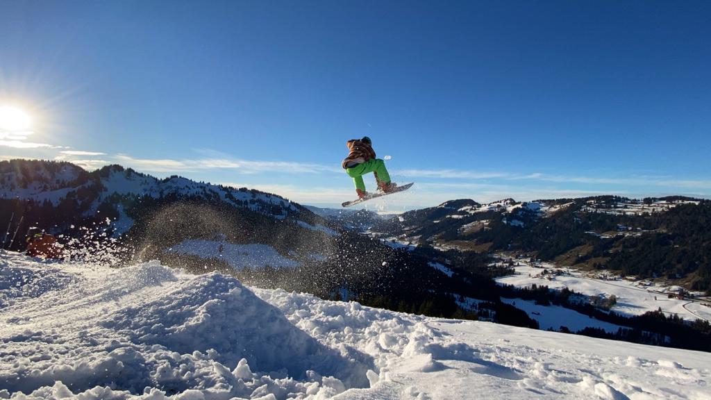 Snowboardfahrer springt über Schanze